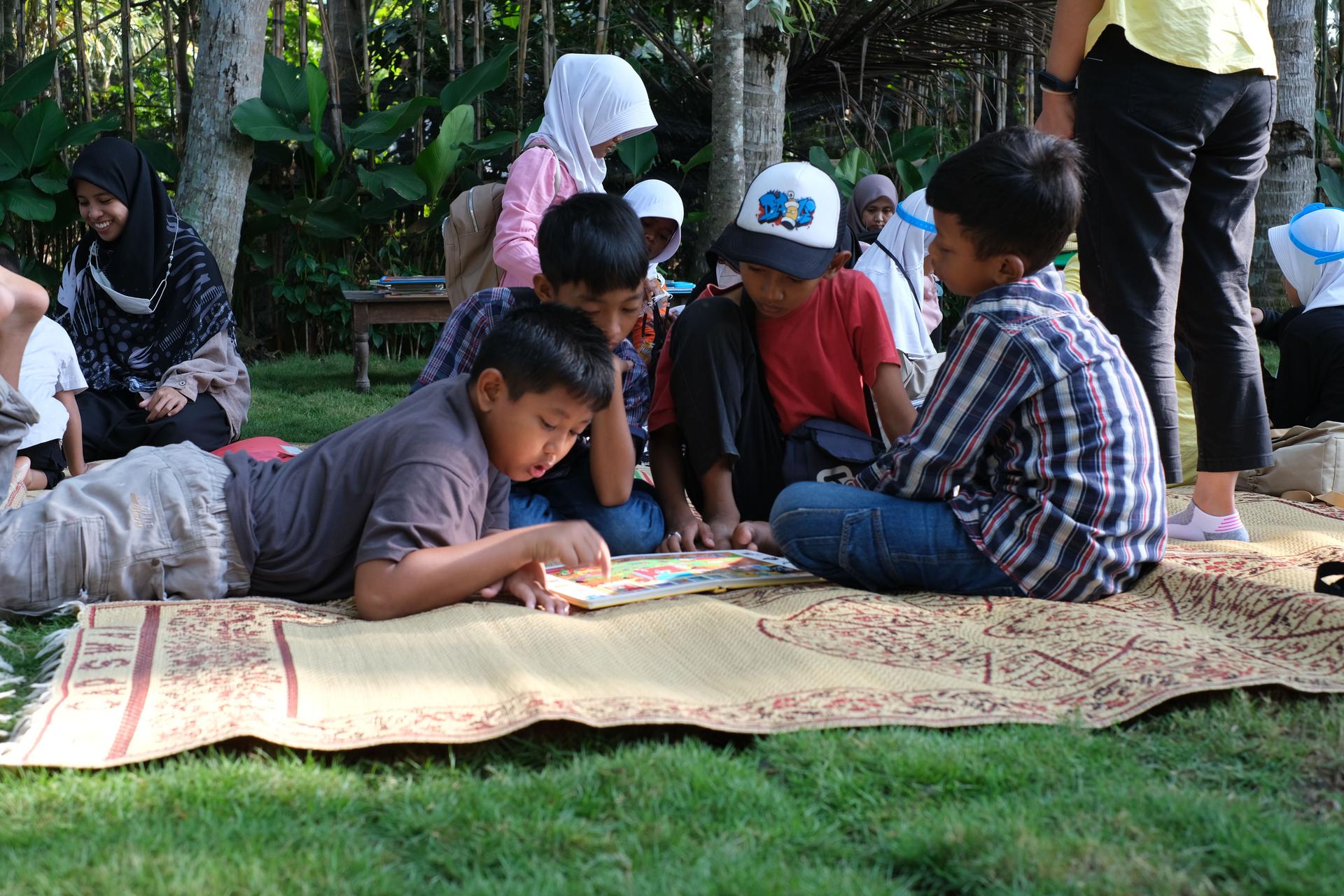 Children reading and learning together outdoors